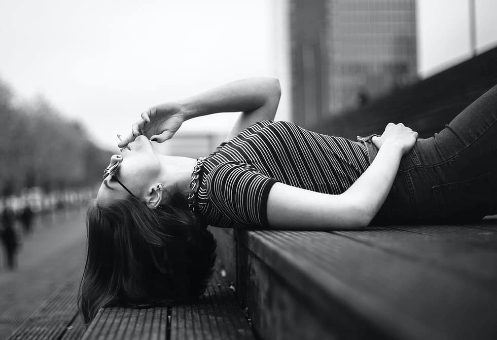woman laying on stairway grayscale photo